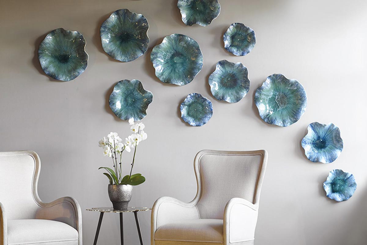 A group of blue and white decorative plates mounted on the wall from Uttermost.